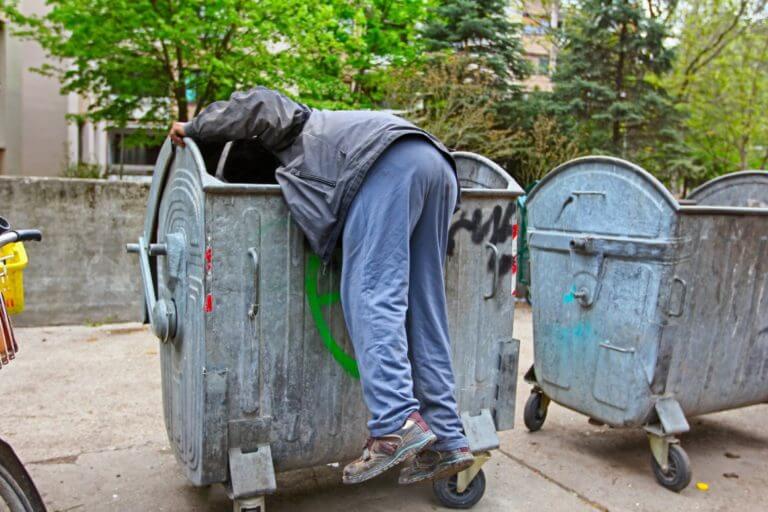 Person diving through a dumpster looking for confidential informatrion