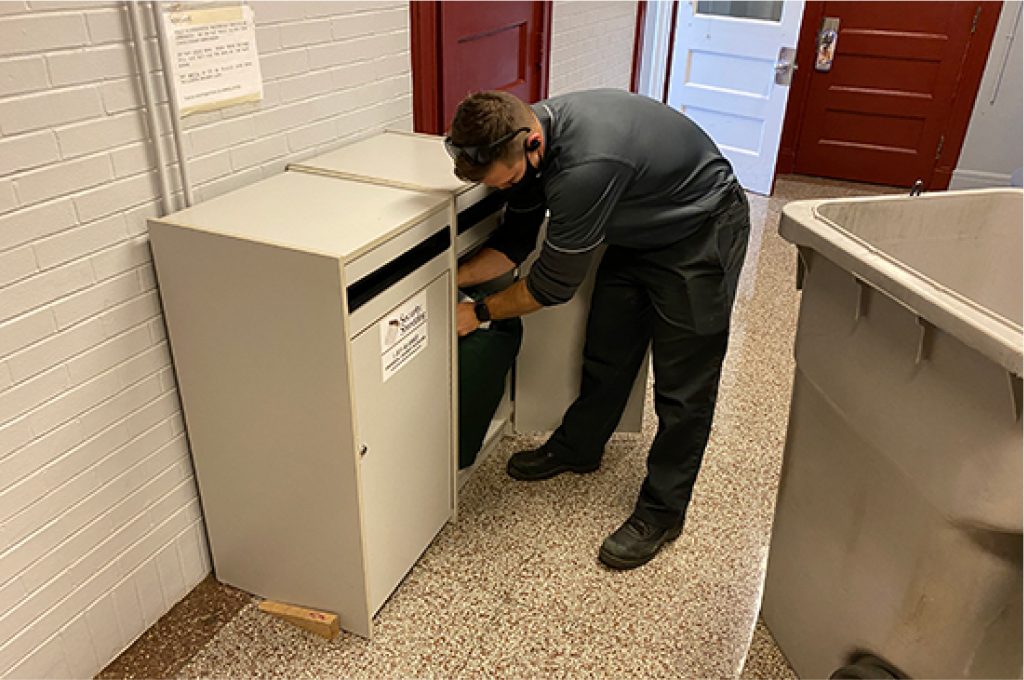 Security Shredding employee emptying a residential shredding console bin