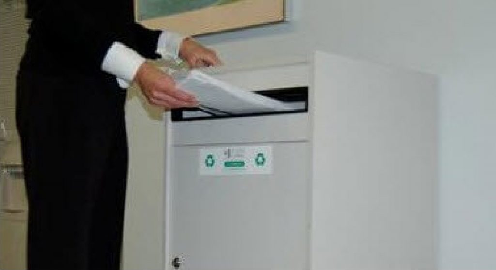 Person putting pile of shredding paper in shredding document storage console