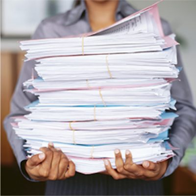 person holding a stack of shredding documents