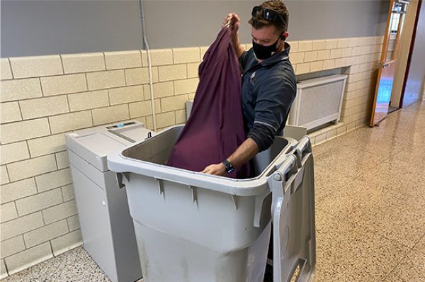 Security Shredding employee picking up shredding documents in a shred bin