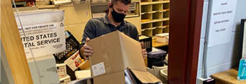 Security Shredding employee emptying a box of shredding paper