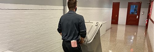 Security Shredding employee moving a shred bin