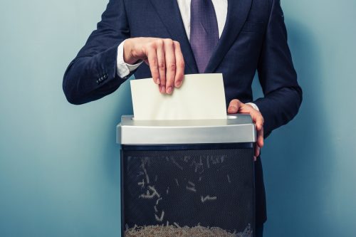 Person putting paper into an office paper shredder
